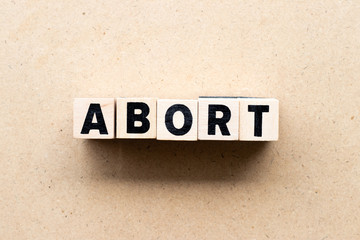 Letter block in word abort on wood background