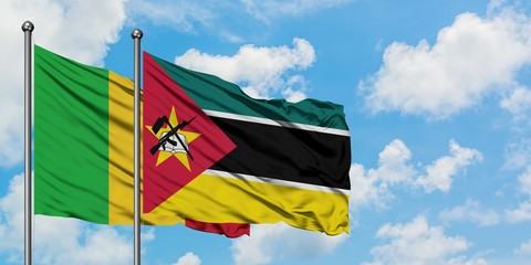 Mali and Mozambique flag waving in the wind against white cloudy blue sky together. Diplomacy...