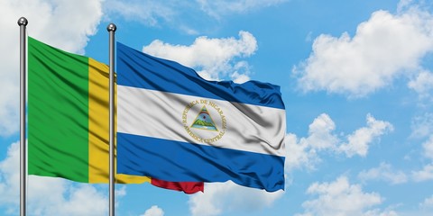 Mali and Nicaragua flag waving in the wind against white cloudy blue sky together. Diplomacy concept, international relations.