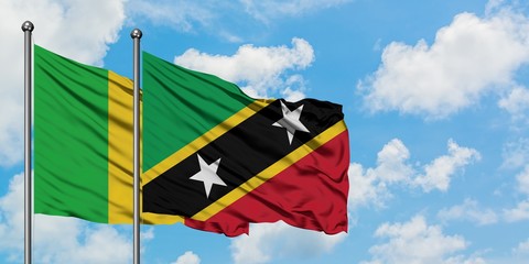 Mali and Saint Kitts And Nevis flag waving in the wind against white cloudy blue sky together. Diplomacy concept, international relations.