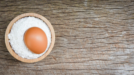 Pastry flour on bowl and rustic wooden background / homemade flour egg cooking ingredients on table