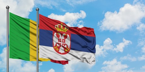 Mali and Serbia flag waving in the wind against white cloudy blue sky together. Diplomacy concept, international relations.