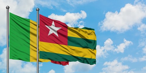 Mali and Togo flag waving in the wind against white cloudy blue sky together. Diplomacy concept, international relations.