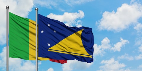 Mali and Tokelau flag waving in the wind against white cloudy blue sky together. Diplomacy concept, international relations.
