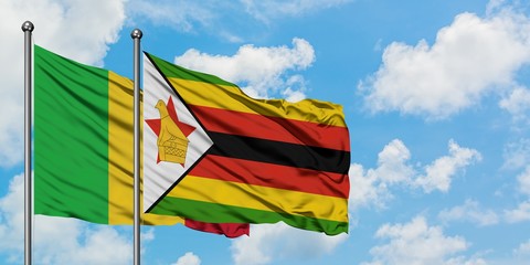 Mali and Zimbabwe flag waving in the wind against white cloudy blue sky together. Diplomacy concept, international relations.