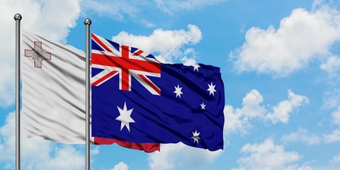 Malta and Australia flag waving in the wind against white cloudy blue sky together. Diplomacy...