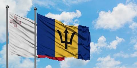 Malta and Barbados flag waving in the wind against white cloudy blue sky together. Diplomacy concept, international relations.