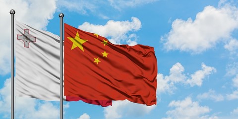 Malta and China flag waving in the wind against white cloudy blue sky together. Diplomacy concept,...