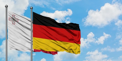 Malta and Germany flag waving in the wind against white cloudy blue sky together. Diplomacy concept, international relations.