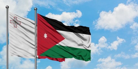 Malta and Jordan flag waving in the wind against white cloudy blue sky together. Diplomacy concept, international relations.