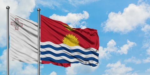 Malta and Kiribati flag waving in the wind against white cloudy blue sky together. Diplomacy concept, international relations.