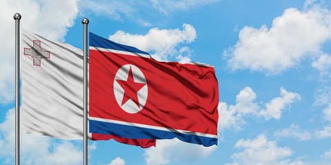 Malta and North Korea flag waving in the wind against white cloudy blue sky together. Diplomacy concept, international relations.