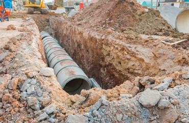 Concrete drainage tube row underground near construction site.Concrete pipe stacked sewage water...
