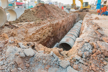 Concrete drainage tube row underground near construction site.Concrete pipe stacked sewage water...