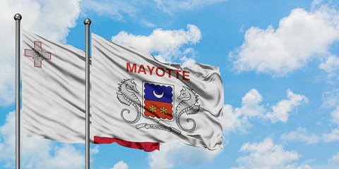Malta and Mayotte flag waving in the wind against white cloudy blue sky together. Diplomacy concept, international relations.