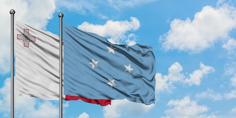 Malta and Micronesia flag waving in the wind against white cloudy blue sky together. Diplomacy...