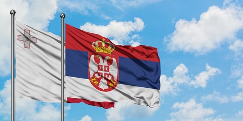 Malta and Serbia flag waving in the wind against white cloudy blue sky together. Diplomacy concept, international relations.