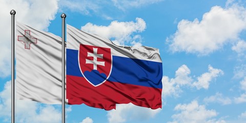 Malta and Slovakia flag waving in the wind against white cloudy blue sky together. Diplomacy concept, international relations.