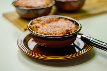 Traditional french onion gratin soup served in a ceramic bowl