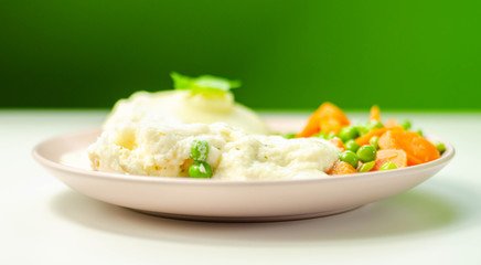 Cod fillet with a creamy cheese sauce, with mashed potato, peas and carrots