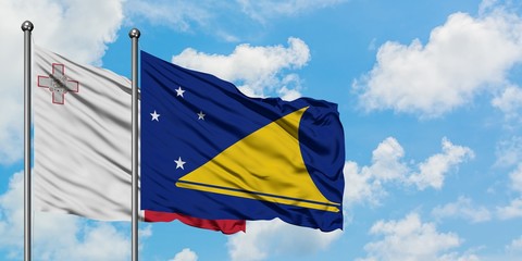 Malta and Tokelau flag waving in the wind against white cloudy blue sky together. Diplomacy concept, international relations.