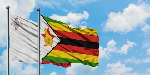 Malta and Zimbabwe flag waving in the wind against white cloudy blue sky together. Diplomacy concept, international relations.