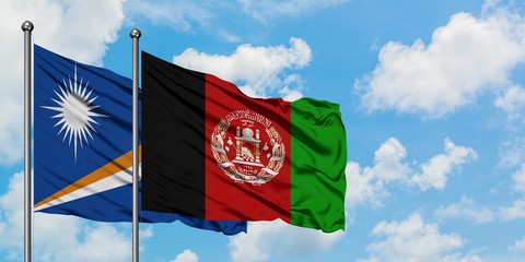 Marshall Islands and Afghanistan flag waving in the wind against white cloudy blue sky together. Diplomacy concept, international relations.