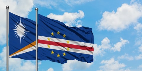 Marshall Islands and Cape Verde flag waving in the wind against white cloudy blue sky together....