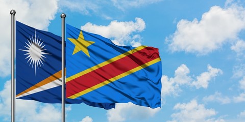 Marshall Islands and Congo flag waving in the wind against white cloudy blue sky together. Diplomacy concept, international relations.