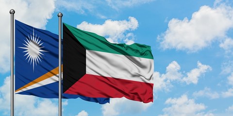 Marshall Islands and Kuwait flag waving in the wind against white cloudy blue sky together. Diplomacy concept, international relations.