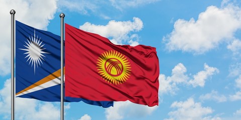 Marshall Islands and Kyrgyzstan flag waving in the wind against white cloudy blue sky together. Diplomacy concept, international relations.