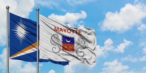 Marshall Islands and Mayotte flag waving in the wind against white cloudy blue sky together. Diplomacy concept, international relations.
