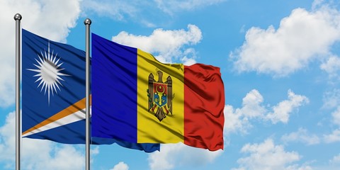 Marshall Islands and Moldova flag waving in the wind against white cloudy blue sky together. Diplomacy concept, international relations.