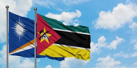 Marshall Islands and Mozambique flag waving in the wind against white cloudy blue sky together. Diplomacy concept, international relations.