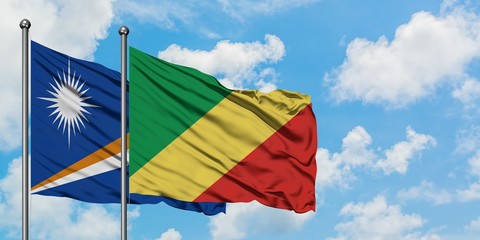 Marshall Islands and Republic Of The Congo flag waving in the wind against white cloudy blue sky together. Diplomacy concept, international relations.