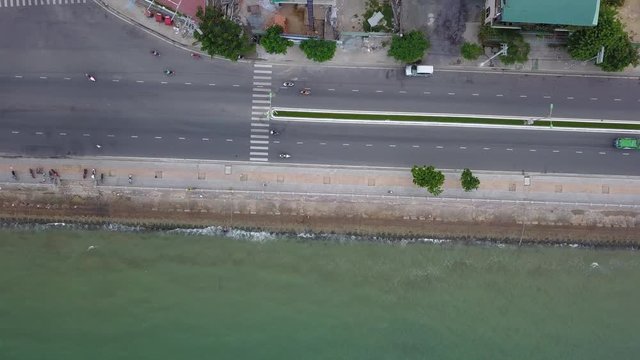 This is still a camera filming a road on the seashore on which the transport goes. In Vietnam