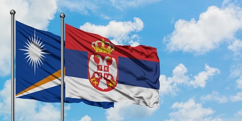 Marshall Islands and Serbia flag waving in the wind against white cloudy blue sky together. Diplomacy concept, international relations.