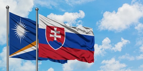 Marshall Islands and Slovakia flag waving in the wind against white cloudy blue sky together. Diplomacy concept, international relations.