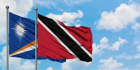 Marshall Islands and Trinidad And Tobago flag waving in the wind against white cloudy blue sky...