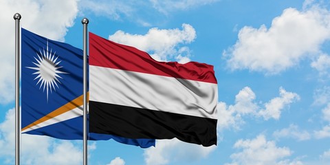 Marshall Islands and Yemen flag waving in the wind against white cloudy blue sky together. Diplomacy concept, international relations.