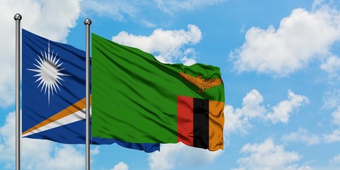 Marshall Islands and Zambia flag waving in the wind against white cloudy blue sky together. Diplomacy concept, international relations.