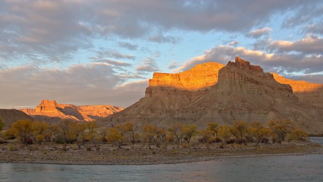 Green River flowing in slow motion during sunrise in Utah as the cliffs light up.