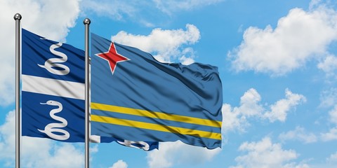 Martinique and Aruba flag waving in the wind against white cloudy blue sky together. Diplomacy concept, international relations.