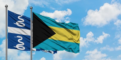 Martinique and Bahamas flag waving in the wind against white cloudy blue sky together. Diplomacy concept, international relations.