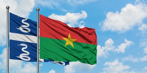 Martinique and Burkina Faso flag waving in the wind against white cloudy blue sky together. Diplomacy concept, international relations.