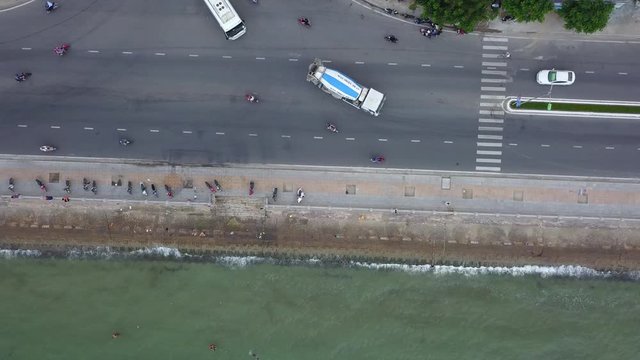 This is still a camera filming a road on the seashore on which the transport goes. In Vietnam