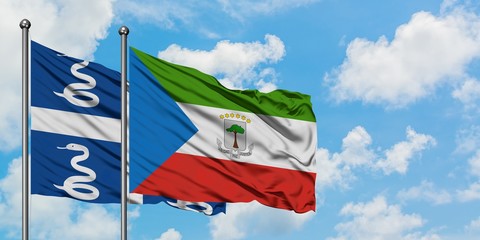 Martinique and Equatorial Guinea flag waving in the wind against white cloudy blue sky together. Diplomacy concept, international relations.