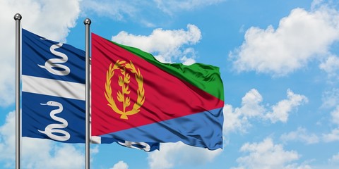 Martinique and Eritrea flag waving in the wind against white cloudy blue sky together. Diplomacy...