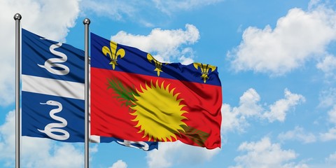 Martinique and Guadeloupe flag waving in the wind against white cloudy blue sky together. Diplomacy concept, international relations.