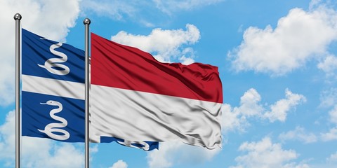 Martinique and Indonesia flag waving in the wind against white cloudy blue sky together. Diplomacy concept, international relations.